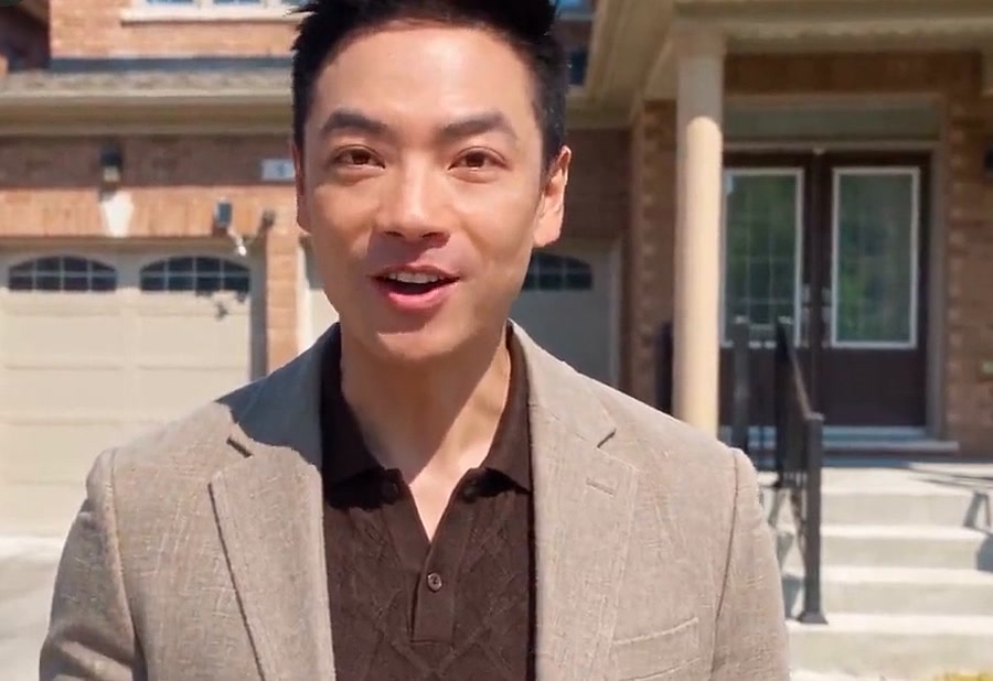 Calvin standing in front of a house listing